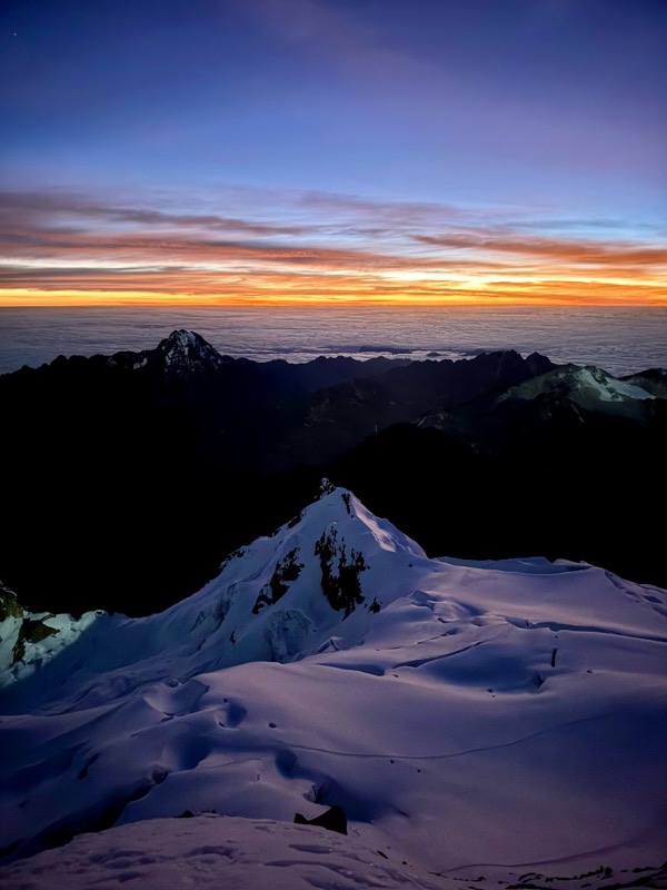 Sunrise over a sea of clouds from the snow ridge of Huayna Potosí